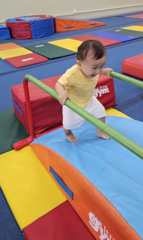 Cute toddler playing on gym equipment